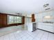 Open floor plan with a kitchen featuring white cabinets and stainless appliances and a living room with lake views at 5720 Half Moon Lake Rd, Tampa, FL 33625