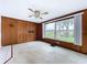 Spacious living room featuring a ceiling fan, large windows, and classic wood paneling at 5720 Half Moon Lake Rd, Tampa, FL 33625