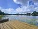 Inviting view of a wooden dock on the lake, surrounded by natural beauty, perfect for waterfront enjoyment and relaxation at 5720 Half Moon Lake Rd, Tampa, FL 33625