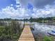 Scenic view of a wooden dock extending into the serene lake, creating a peaceful waterfront experience at 5720 Half Moon Lake Rd, Tampa, FL 33625