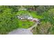 Expansive aerial view of a lovely white home with beautiful landscaping and a circular driveway at 5933 Carina Trce, Wesley Chapel, FL 33545