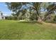 A vast backyard features mature trees, lush green grass, and a storage shed at 5933 Carina Trce, Wesley Chapel, FL 33545