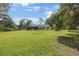 Sprawling backyard featuring a well-maintained lawn, mature trees and a covered patio, perfect for outdoor enjoyment at 5933 Carina Trce, Wesley Chapel, FL 33545