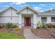 Inviting front entrance features a red door, brick accents, and lush landscaping, for great curb appeal at 5933 Carina Trce, Wesley Chapel, FL 33545