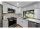 Modern kitchen features white cabinets, stainless steel appliances, and a subway tile backsplash at 5933 Carina Trce, Wesley Chapel, FL 33545