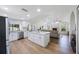 Open-concept kitchen with a large island, white cabinets, stainless steel appliances, and an adjacent living area at 5933 Carina Trce, Wesley Chapel, FL 33545
