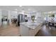 Bright, open kitchen featuring white cabinetry, stainless steel appliances, and a large island with granite countertops at 5933 Carina Trce, Wesley Chapel, FL 33545