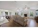 Open-concept living room with a fireplace, ceiling fans, and adjacent breakfast nook with backyard views at 5933 Carina Trce, Wesley Chapel, FL 33545