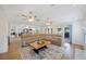 Open living area with a sectional sofa, fireplace, and direct access to the kitchen and backyard patio at 5933 Carina Trce, Wesley Chapel, FL 33545