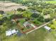 Aerial view of property with large yard, mature trees, and a circular driveway, surrounded by green landscape at 611 Robinson Oaks Ln, Plant City, FL 33567