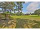 A large backyard with a house, trees, and a play area for children at 611 Robinson Oaks Ln, Plant City, FL 33567