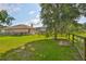 Expansive backyard featuring lush green grass, mature trees, a playground, and fencing at 611 Robinson Oaks Ln, Plant City, FL 33567
