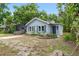 Quaint one-story home with light-blue exterior, picket fence, and lush landscaping at 6489 30Th N St, St Petersburg, FL 33702