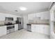 Modern kitchen with white cabinetry, stainless steel appliances, granite countertops and sleek tile flooring at 6489 30Th N St, St Petersburg, FL 33702