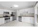 Bright, updated kitchen featuring white cabinets, granite countertops, stainless steel appliances, and marble-look tile floors at 6489 30Th N St, St Petersburg, FL 33702