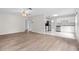 Open-concept living area with wood-look flooring connecting the living room and kitchen with stainless appliances at 6489 30Th N St, St Petersburg, FL 33702