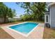 Inviting backyard pool, surrounded by well-maintained landscaping and a view of the blue sky at 6489 30Th N St, St Petersburg, FL 33702
