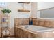 A bathroom featuring a built-in tub with travertine surround, and a built-in shelf for towels at 6611 Surfside Blvd, Apollo Beach, FL 33572