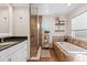 Bright bathroom featuring a soaking tub with stone surround and a glass-enclosed shower with tile at 6611 Surfside Blvd, Apollo Beach, FL 33572