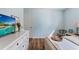 Serene bedroom with light blue walls, wood floors, and bright lighting at 6611 Surfside Blvd, Apollo Beach, FL 33572