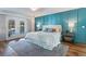 Bedroom features paneled accent wall, French doors to backyard pool, and wood flooring at 6611 Surfside Blvd, Apollo Beach, FL 33572