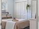 Cozy bedroom with natural light, neutral tones, and closet with shutter style doors at 6611 Surfside Blvd, Apollo Beach, FL 33572