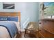 Bedroom view of woven chair, dresser, and coastal decor with beach art and light blue wall at 6611 Surfside Blvd, Apollo Beach, FL 33572