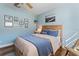 A cozy bedroom with a light blue walls and beachy decor featuring a wooden frame bed and relaxing coastal accents at 6611 Surfside Blvd, Apollo Beach, FL 33572