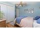 Bedroom with a ceiling fan, blue walls, wood floors, and natural lighting at 6611 Surfside Blvd, Apollo Beach, FL 33572