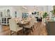 Bright dining room featuring a wood table with six upholstered chairs, and a view into the living area at 6611 Surfside Blvd, Apollo Beach, FL 33572