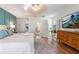Bright main bedroom with wood floors, modern lighting, and a glimpse into the hallway at 6611 Surfside Blvd, Apollo Beach, FL 33572
