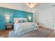 Spacious main bedroom featuring a blue accent wall, ceiling fan, and a well-lit en-suite bathroom at 6611 Surfside Blvd, Apollo Beach, FL 33572