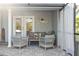Cozy patio with wicker furniture, soft curtains, and views of the pool and backyard, inviting outdoor relaxation at 6611 Surfside Blvd, Apollo Beach, FL 33572