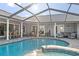 Backyard pool featuring a spa, screened enclosure, and a patio with outdoor seating at 6611 Surfside Blvd, Apollo Beach, FL 33572