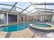 Backyard pool featuring a spa, screened enclosure, and a patio for entertaining at 6611 Surfside Blvd, Apollo Beach, FL 33572