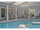 Backyard pool featuring a spa, screened enclosure, and patio with outdoor dining at 6611 Surfside Blvd, Apollo Beach, FL 33572