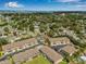 An aerial view of a residential neighborhood with trees, a community pool, and water views at 6627 Date Palm S Ave, St Petersburg, FL 33707