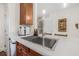 Modern kitchen featuring a stainless steel sink, stylish faucet, quartz countertops and wood cabinetry at 6627 Date Palm S Ave, St Petersburg, FL 33707