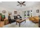Spacious living room featuring a leather sofa, armchair, ceiling fan, and access to the outdoors at 6627 Date Palm S Ave, St Petersburg, FL 33707
