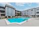 Inviting condominium pool area with lounge chairs, umbrellas, and a clear view of the well-maintained building at 701 Poinsettia Rd # 340, Belleair, FL 33756
