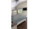 Bedroom features a bed with grey linens, a window, a wall-mounted TV, and a high ceiling at 7152 Sandy Ln, Wesley Chapel, FL 33544