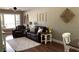 Comfortable living room featuring leather sofas, decorative pieces, and natural light at 7152 Sandy Ln, Wesley Chapel, FL 33544