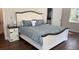 Main bedroom with decorative wood frame bed, wood floors, and lots of natural light at 7152 Sandy Ln, Wesley Chapel, FL 33544