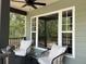 Inviting porch with ceiling fan, large windows, and seating provides the perfect spot to relax at 7152 Sandy Ln, Wesley Chapel, FL 33544