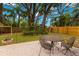Backyard featuring a cozy firepit, outdoor seating, and a wooden fence enclosing the green space at 717 E 137Th Ave, Tampa, FL 33613