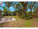 A spacious backyard featuring a patio with outdoor seating, a play area, and mature trees for privacy at 717 E 137Th Ave, Tampa, FL 33613