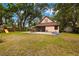 A spacious backyard with an outdoor patio, a playset, mature trees, and room to enjoy outdoor living at 717 E 137Th Ave, Tampa, FL 33613
