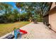 Large backyard with a patio, outdoor furniture, a grill, play set, and mature trees providing plenty of shade at 717 E 137Th Ave, Tampa, FL 33613