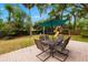 Backyard view of a patio with outdoor furniture and a playset, all beneath the shade of mature trees at 717 E 137Th Ave, Tampa, FL 33613
