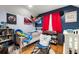 bedroom with a crib, bed, and a hammock for stuffed animals, with blue accent wall and hardwood floors at 717 E 137Th Ave, Tampa, FL 33613